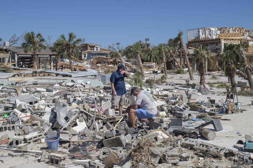 Residents survey debris after Hurricane Michael hit in Mexico Beach, Florida, U.S., on Friday, Oct. 12, 2018. Search-and-rescue teams found at least one body in Mexico Beach, the ground-zero town nearly obliterated by Hurricane Michael, an official …